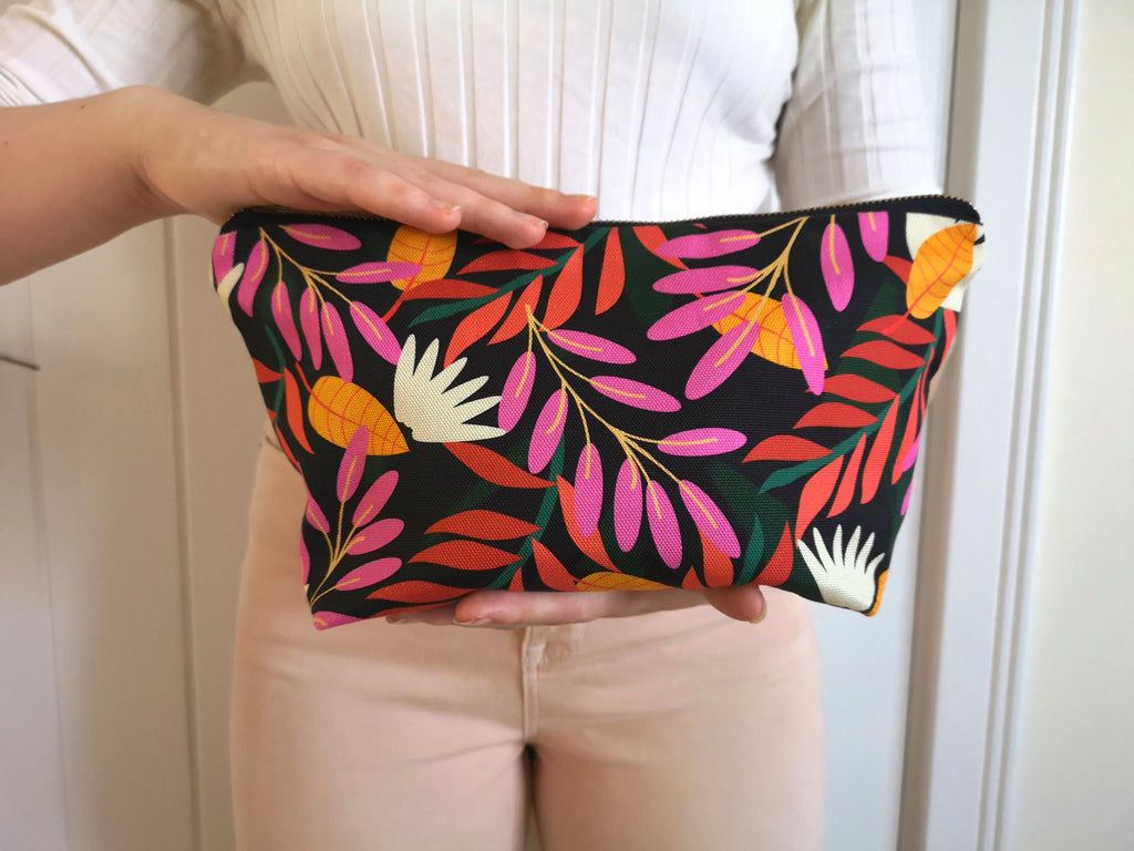 Large Floral Toiletry Wash Bag for Women, colourful, bright and stylish, with a quality brass YKK zip, closed, held by a woman, to show the scale.