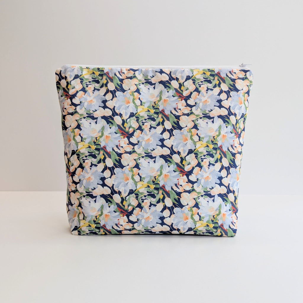 Large Cotton Wash Bag, featuring a stunning blossoming floral pattern design on a dark blue background, with polyester waterproof lining and a quality white nylon zip, on a white background.