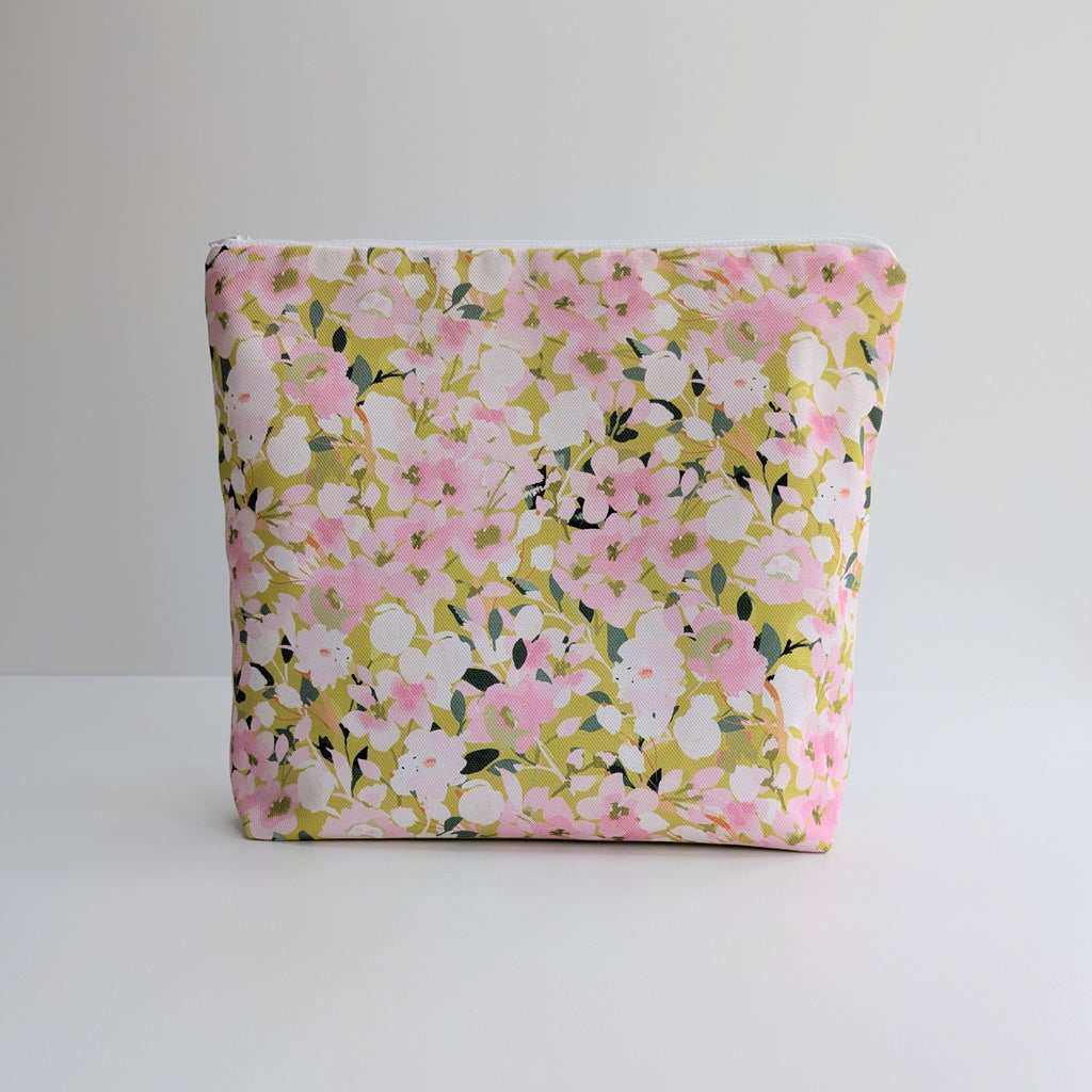 Large Wash Bag, adorned with a stunning cherry blossom floral design, featuring pink cherry blossom on a light green background, with waterproof lining and a quality white nylon zip, on a white and grey background.