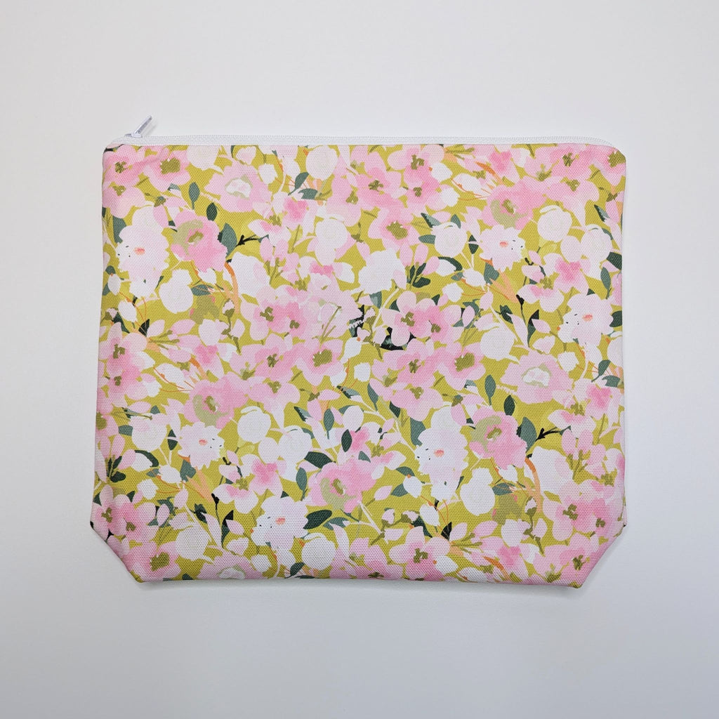 Large Wash Bag, adorned with a stunning cherry blossom floral design, featuring pink cherry blossom on a light green background, with waterproof lining and a quality white nylon zip, lying flat, on a white background.