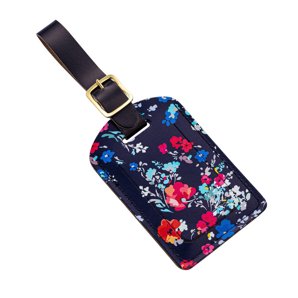Recycled Leather Luggage Tag featuring dark blue floral print pattern, with flap covering personal details card, with a strap finished with a sleek gold-plated buckle to attach to luggage, photographed at an angle, on a white background.