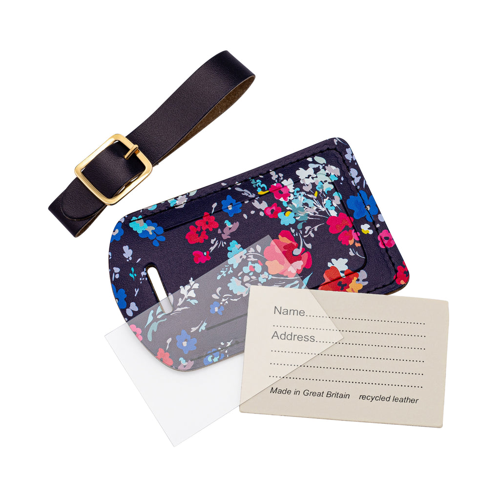Recycled Leather Luggage Tag featuring dark blue floral print pattern, in parts, including a tag, a strap finished with a sleek gold-plated buckle, an address card and a plastic address card cover, all on a white background.