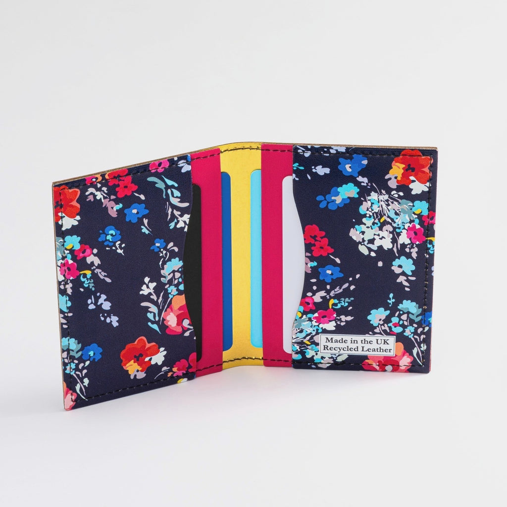 Recycled Leather Folding Wallet Card Holder for women, featuring a floral pattern on a dark navy-blue background, with four slots, with cards in, on a white background.