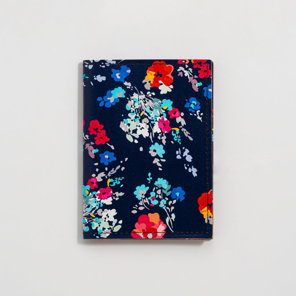 Recycled Leather Folding Wallet Card Holder for women, featuring a floral pattern on a dark navy-blue background, closed, on a white background.