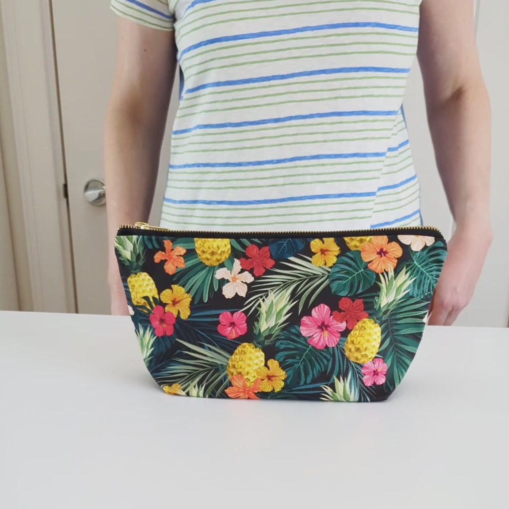 Large Toiletry Wash Bag for women featuring Tropical Pineapple Floral Print, rotated and then unzipped to show the black lining.